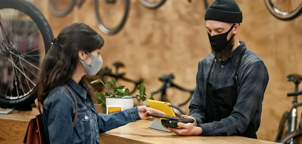 Person quickly taps their phone to pay for a purchase with a digital wallet.